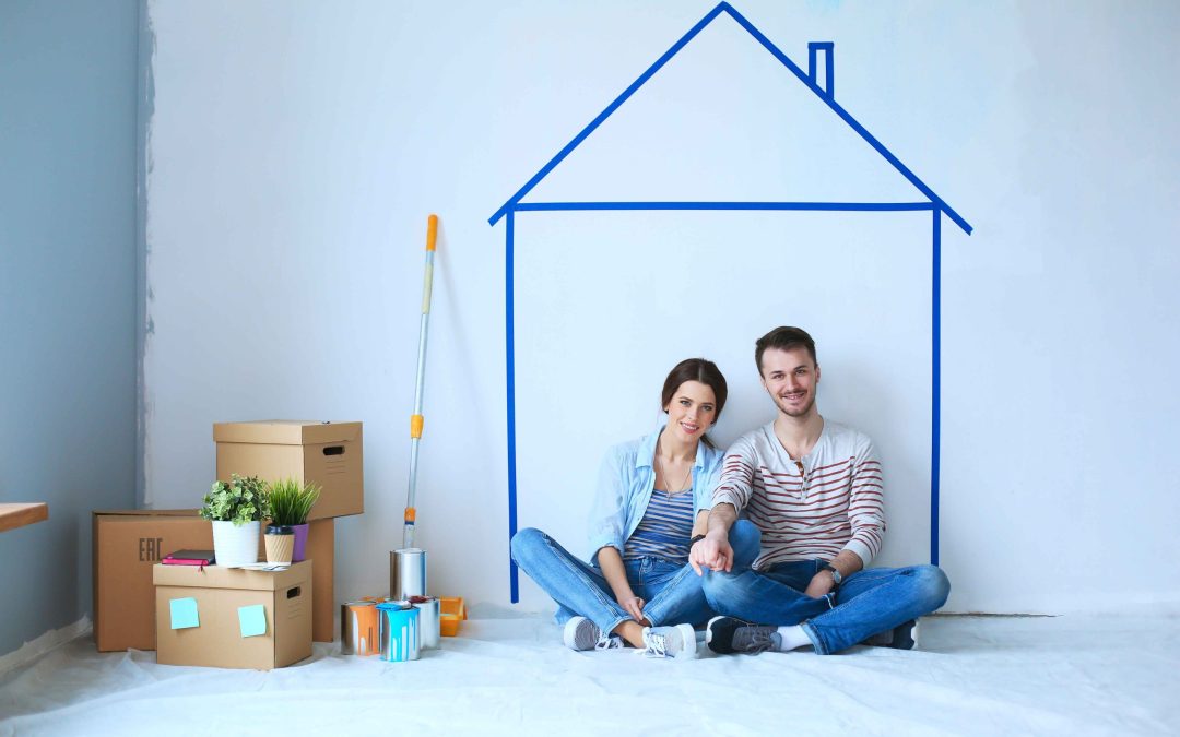 Couple sitting in front of painted home on wall