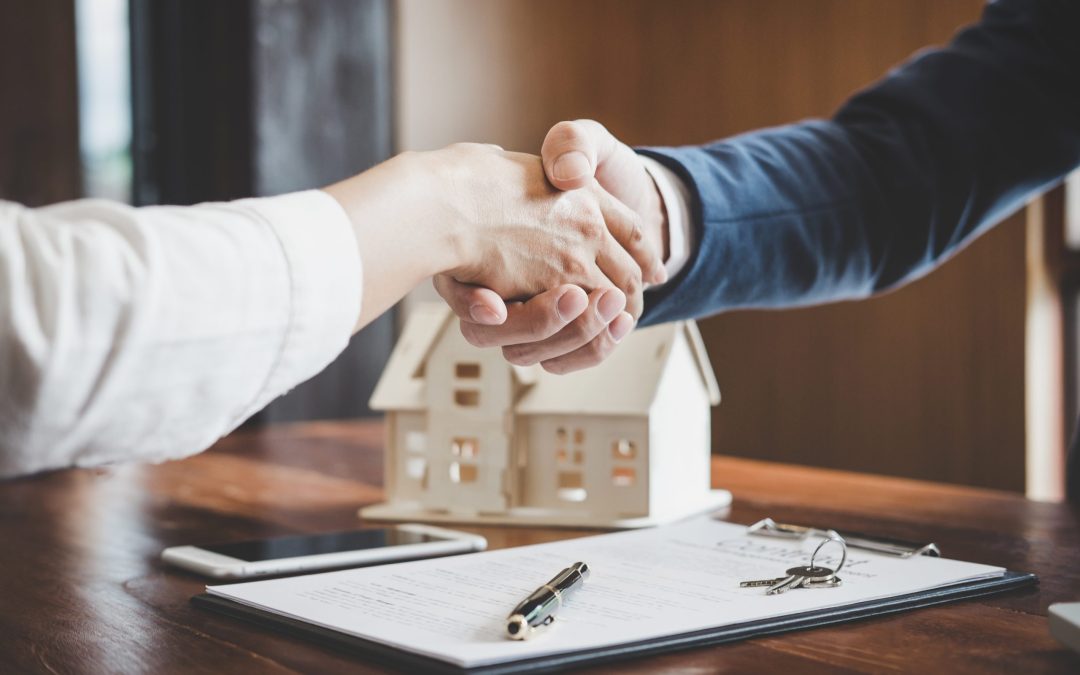 Estate agent and customer shaking hands after finished contract after about home insurance and investment loan